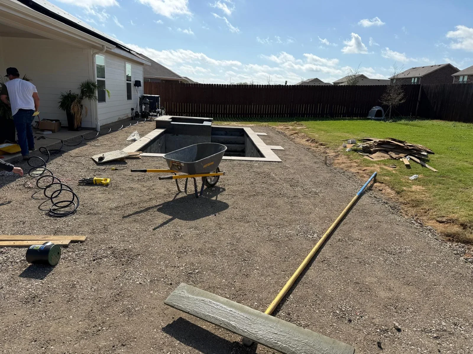 In-ground concrete fire pit with rectangular basin and seating ledges during construction phase